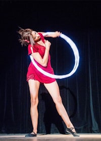 a woman in a red dress doing a hula hoop