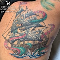 a tattoo of a pirate ship with octopus tentacles