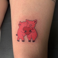 a tattoo of two pigs holding a heart