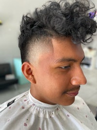 a man with curly hair in a barber shop