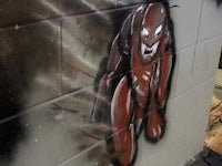 a graffiti painting of a red man on a wall