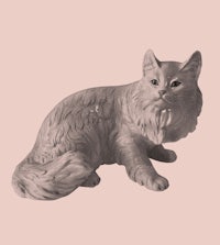 a statue of a cat on a pink background