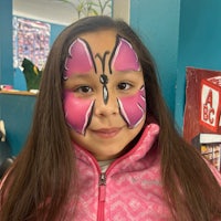 a girl with a pink butterfly painted on her face