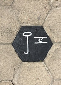 the letter j is painted on a brick sidewalk