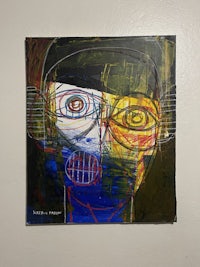 a painting of a man with a blue and yellow face on a wall