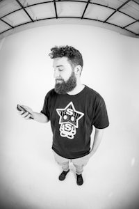 a man with a beard is holding a cell phone