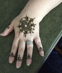 a woman's hand with a henna design on it