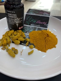 tumeric powder on a plate next to a bottle of tumeric