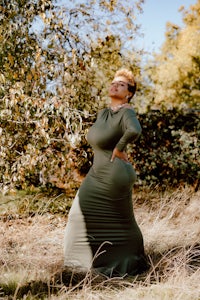 a woman in a green dress posing in a field
