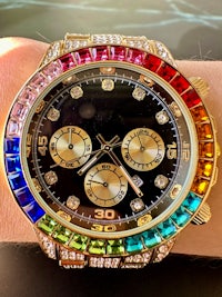 a man's wrist with a rainbow colored watch