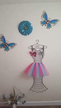 a pink and blue tutu hanging on a wall with butterflies