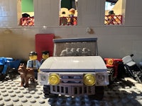 lego minifigures in a room with a toy car
