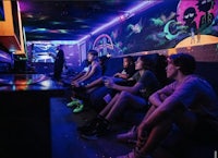 a group of people playing video games in a dark room