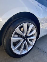 a close up of the wheel of a white car