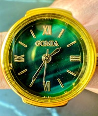 a green watch on a person's hand