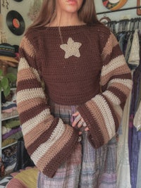 a woman wearing a crocheted sweater with a star on it