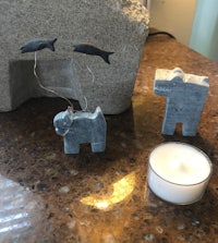 small figurines of a dog and a whale next to a candle