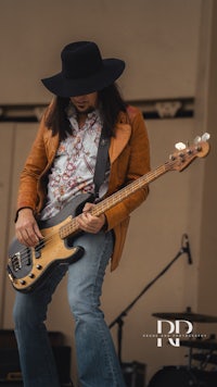 a man in a hat playing a bass