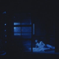 a man laying on a bed in a dark room