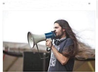 a man with long hair holding a megaphone