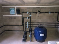a swimming pool with a blue water pump and pipes