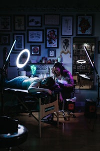 a woman is getting tattooed in a dark room