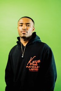 a man wearing a black hoodie with orange lettering