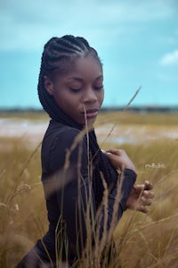 a young woman in a field with braids