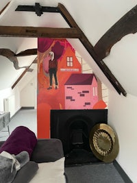 a room with a fireplace and a mural on the wall