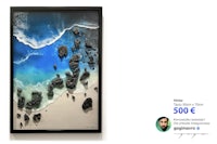 a framed painting of a beach scene with rocks and sand