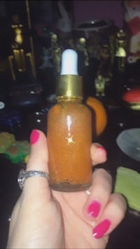 a person holding a bottle of orange oil