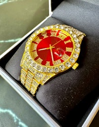 a gold and red watch in a box