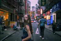 a woman is standing on a street in an asian city