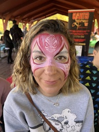 a woman with a pink face paint