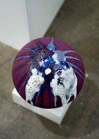 a red, blue, and white ball on a white pedestal