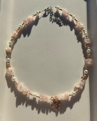 a necklace with pink and white beads and pearls