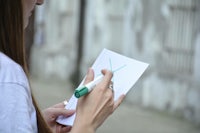 a woman writing on a piece of paper with a marker