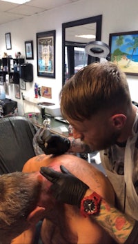 a man getting a tattoo at a tattoo shop