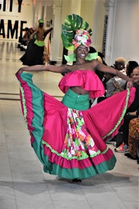 a woman in a colorful dress on a runway