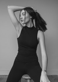 a woman posing on a stool in black leggings