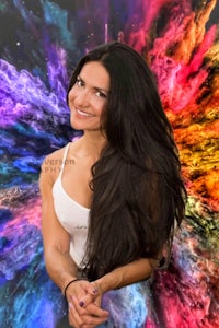 a woman posing in front of a colorful background