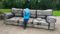 a person sitting on a couch in a park