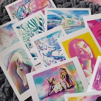 a collection of colorful art prints laying on a blanket