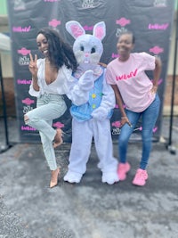 two women posing for a photo with an easter bunny