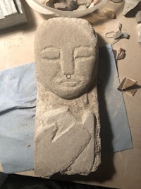 a piece of stone with a face on it