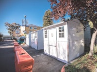 a row of white portable restrooms in a parking lot