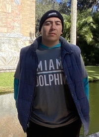 a young man wearing a miami dolphins t - shirt