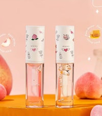 two bottles of peach flavored lip balm on an orange background
