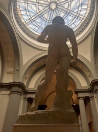 a statue of a man in front of a dome