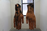 a pair of muddy hands hanging on a clothes line